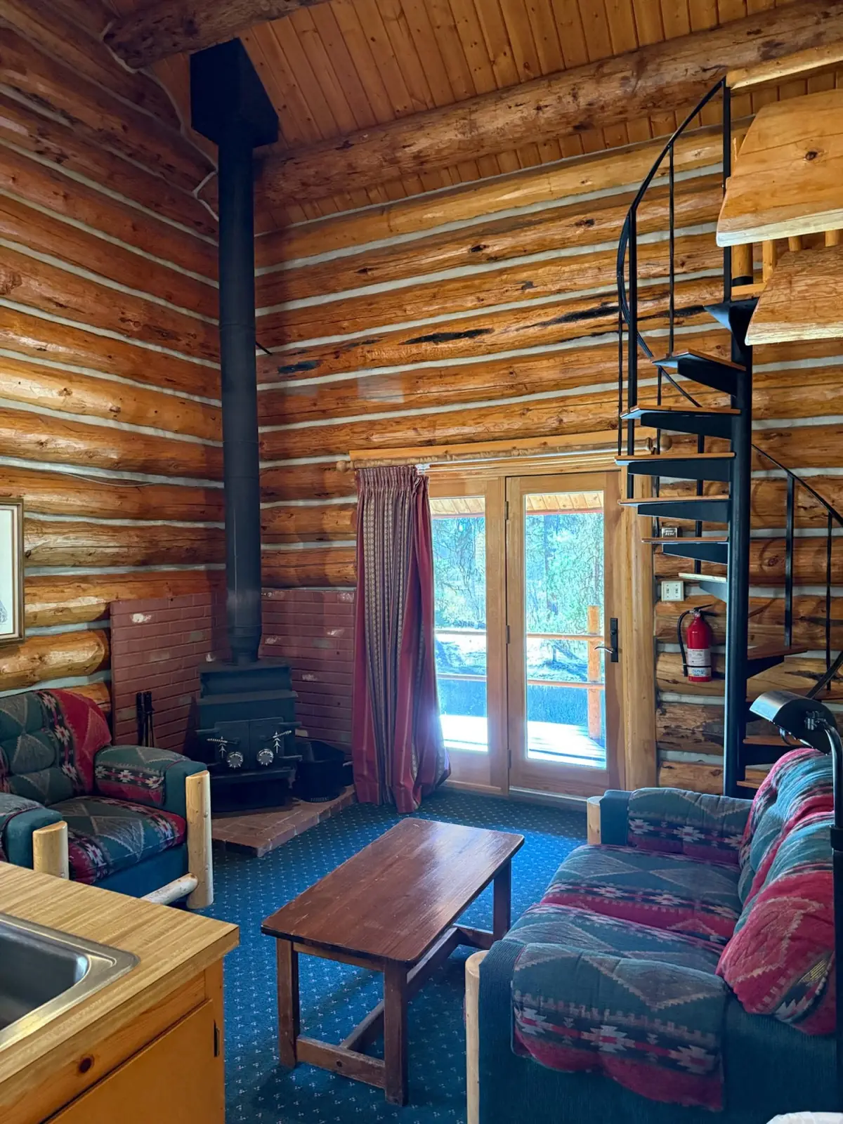 Cabin living room with a spiral stair up to the loft