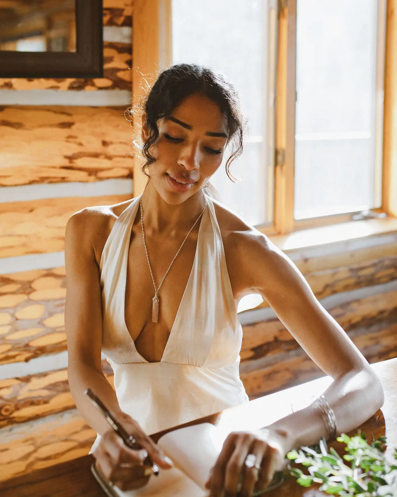 A bride writing her vows by a cabin window