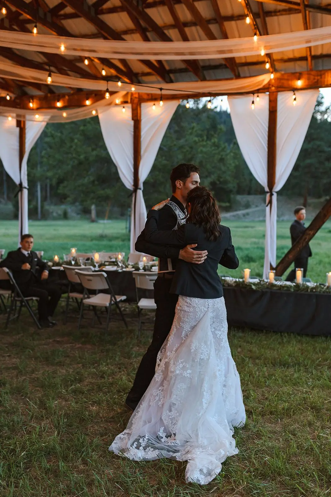 A couple dancing beneath the hangar roof and string lights
